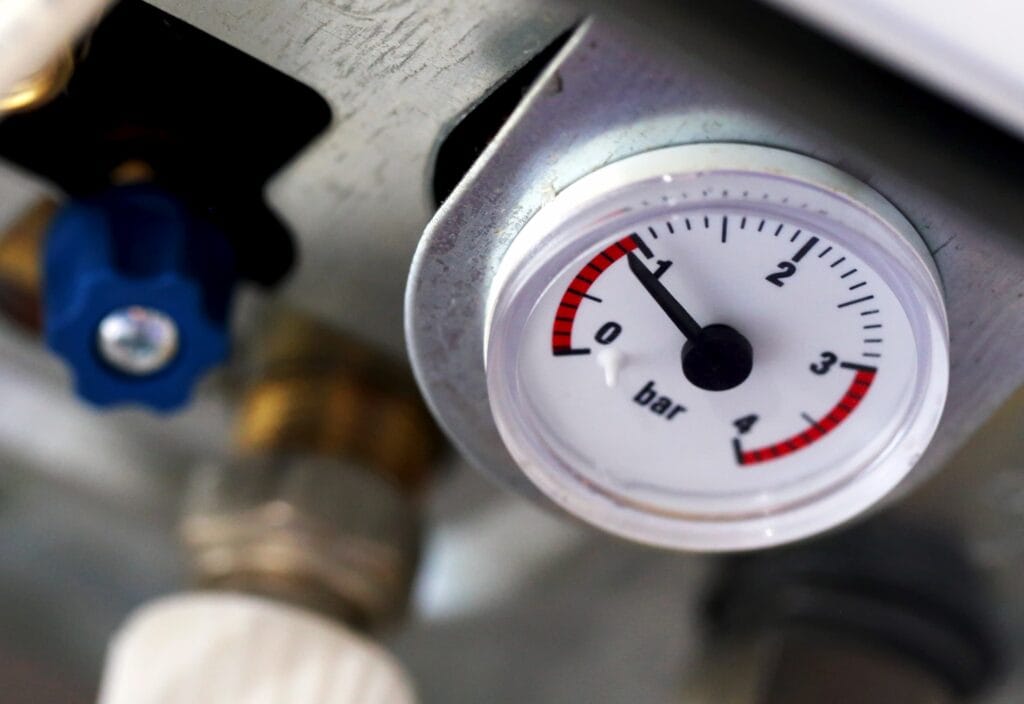 A close-up view of a pressure gauge on a gas boiler.